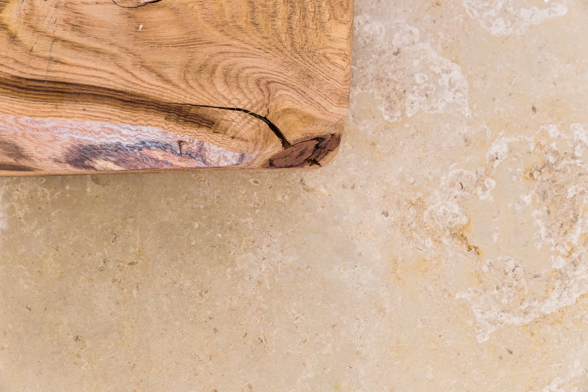 Primo piano di legno massello appoggiato su pietra chiara con venature naturali