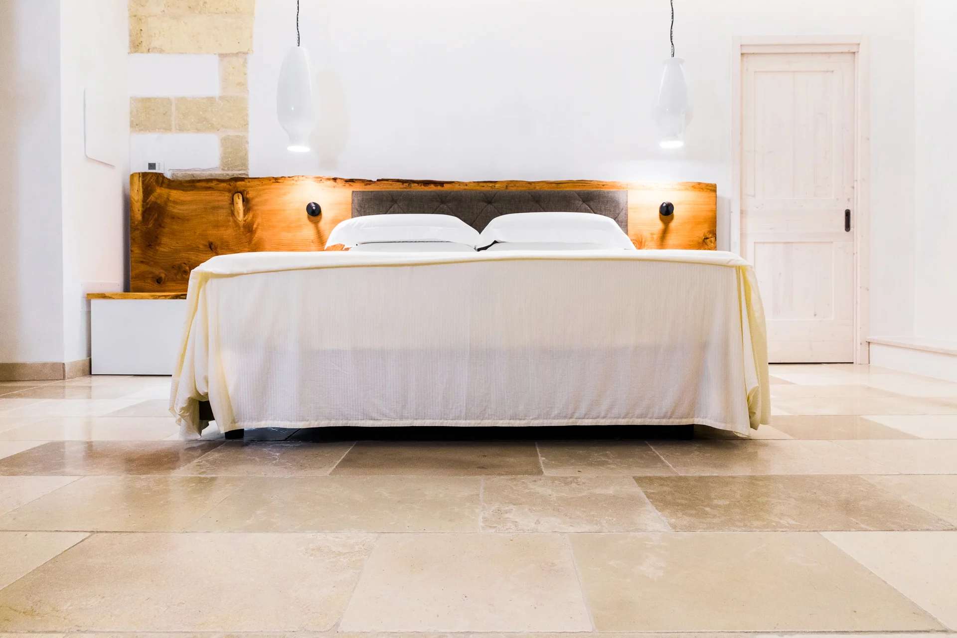 Camera da letto con pavimento in Pietra di Trani e testiera in legno