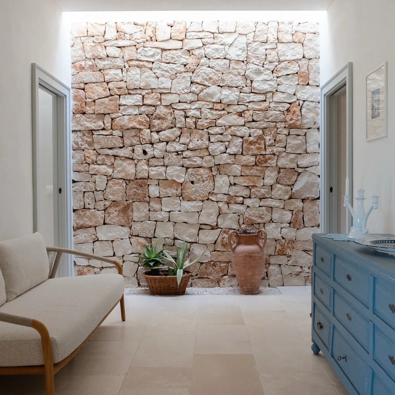 Interior wall clad in Trani stone beside a pale floor