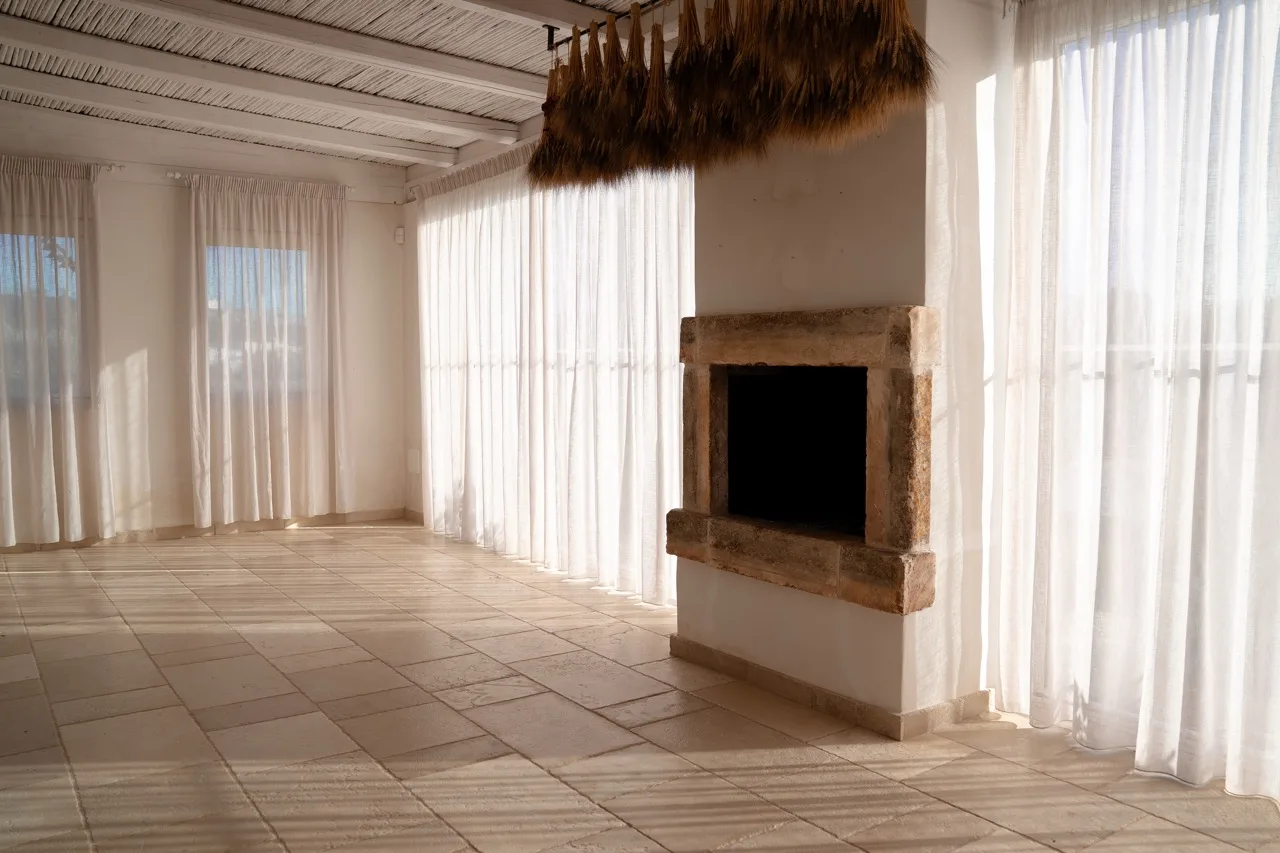 Living room with a fireplace and a pale Trani stone floor