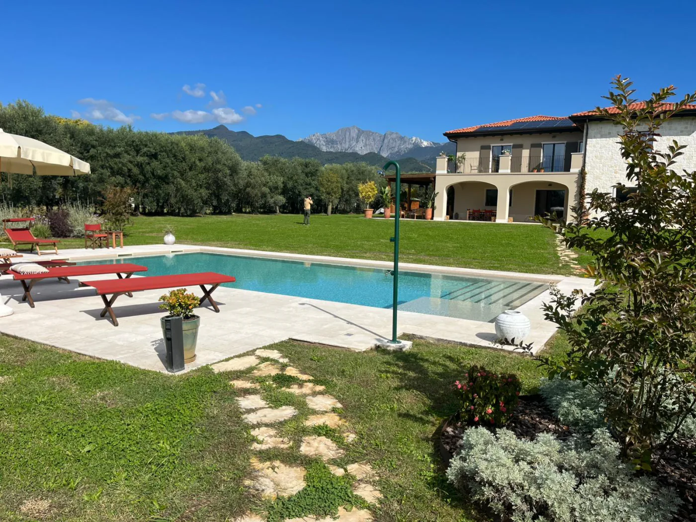Bordo piscina e solarium in pietra Linea Rustica in una villa con giardino