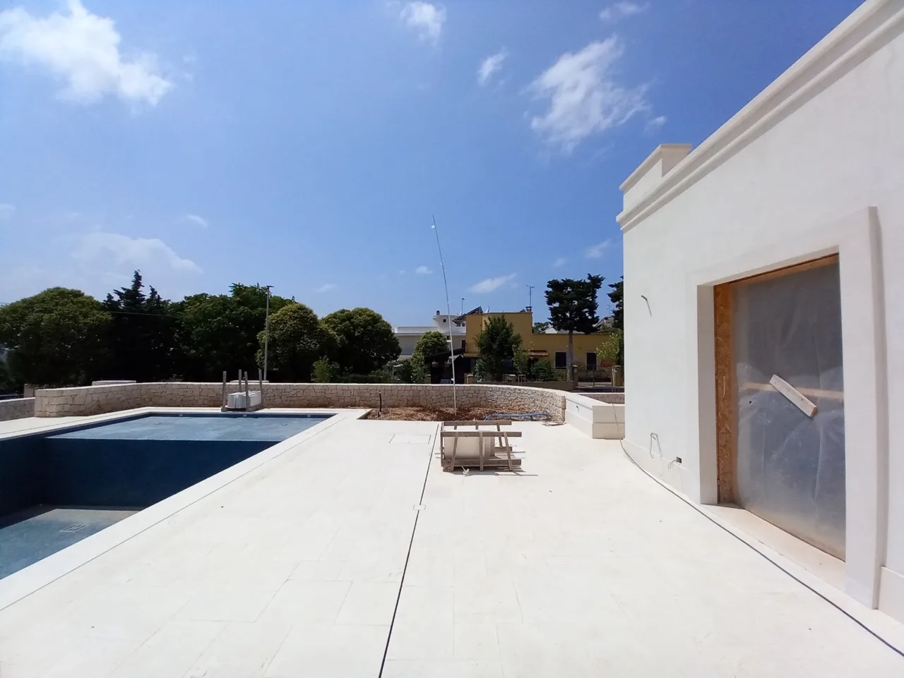 Outdoor sun deck paved in white Trani chianca beside the pool