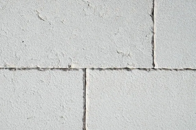 Close-up of bush-hammered Trani marble slabs with a rough, grainy surface