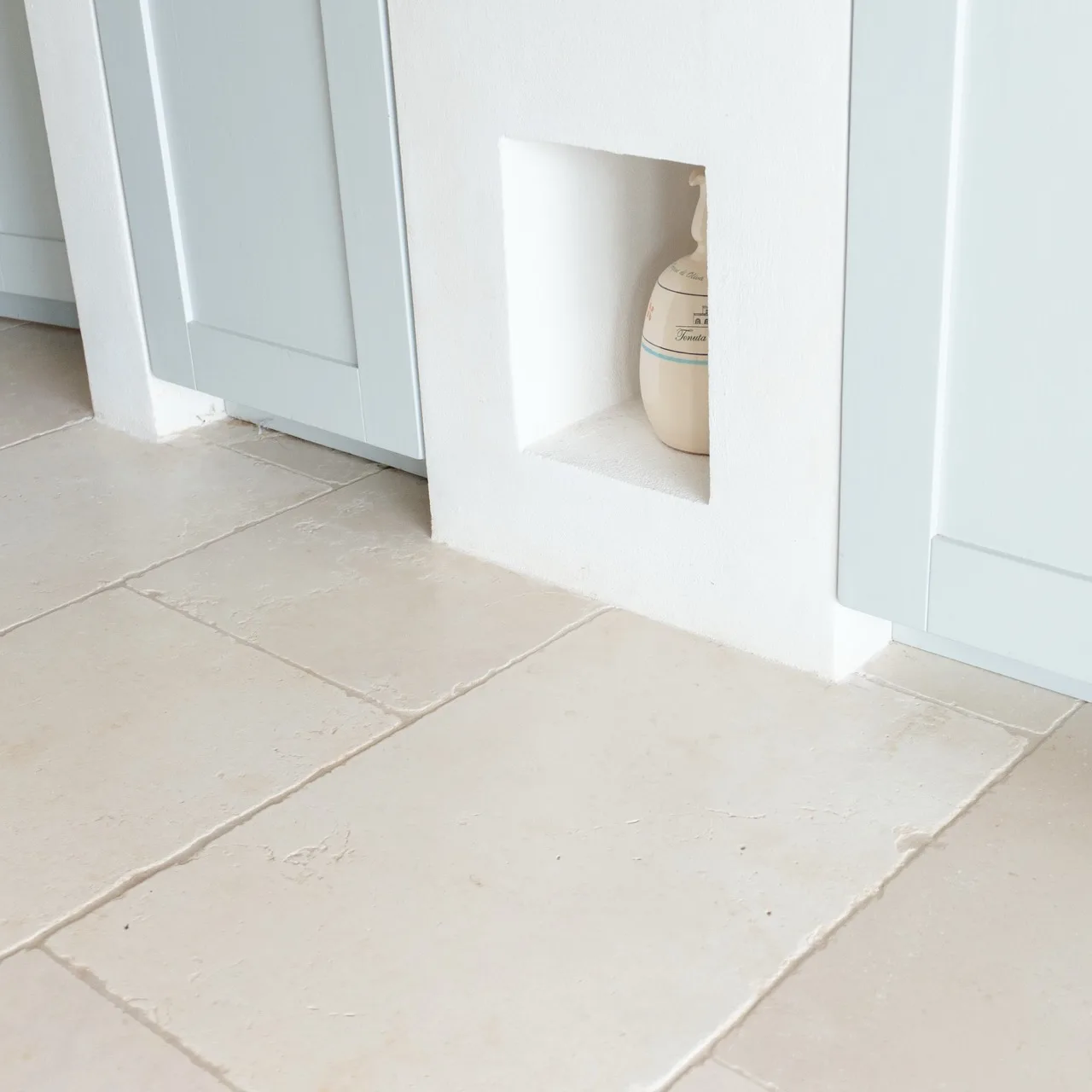 Indoor floor in uniform white Trani marble in a masonry kitchen