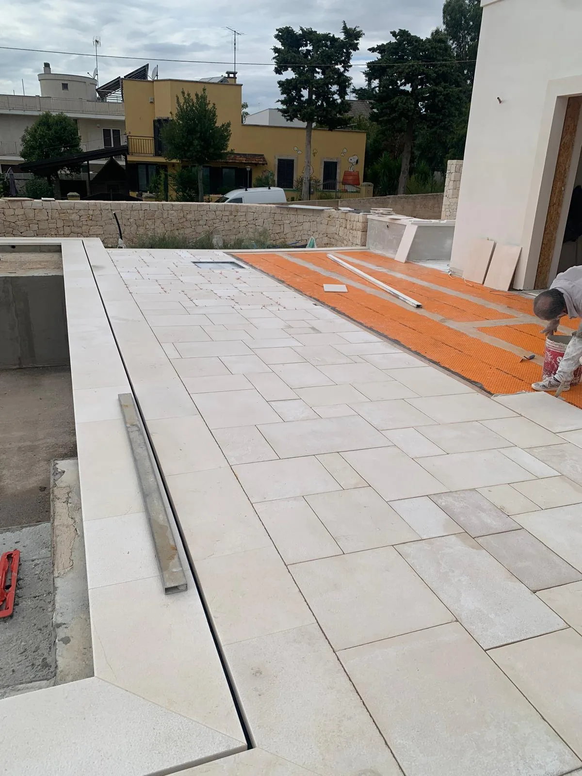 Solarium esterno pavimentato in chianca di Trani bianca accanto alla piscina
