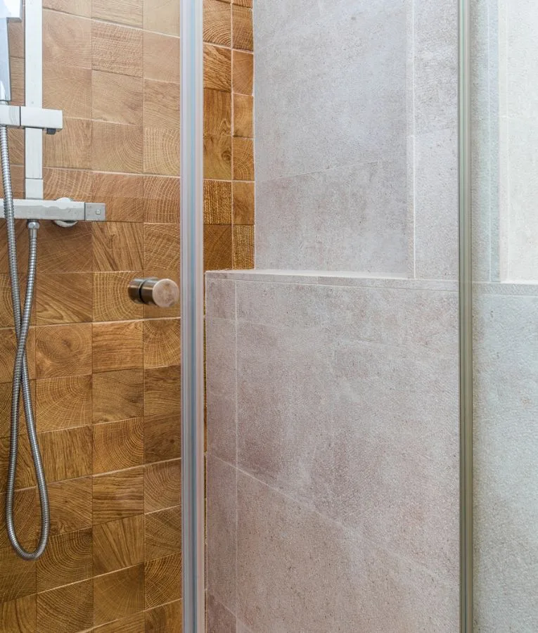 Doccia con rivestimento in lastre chiare e parete in mosaico di legno