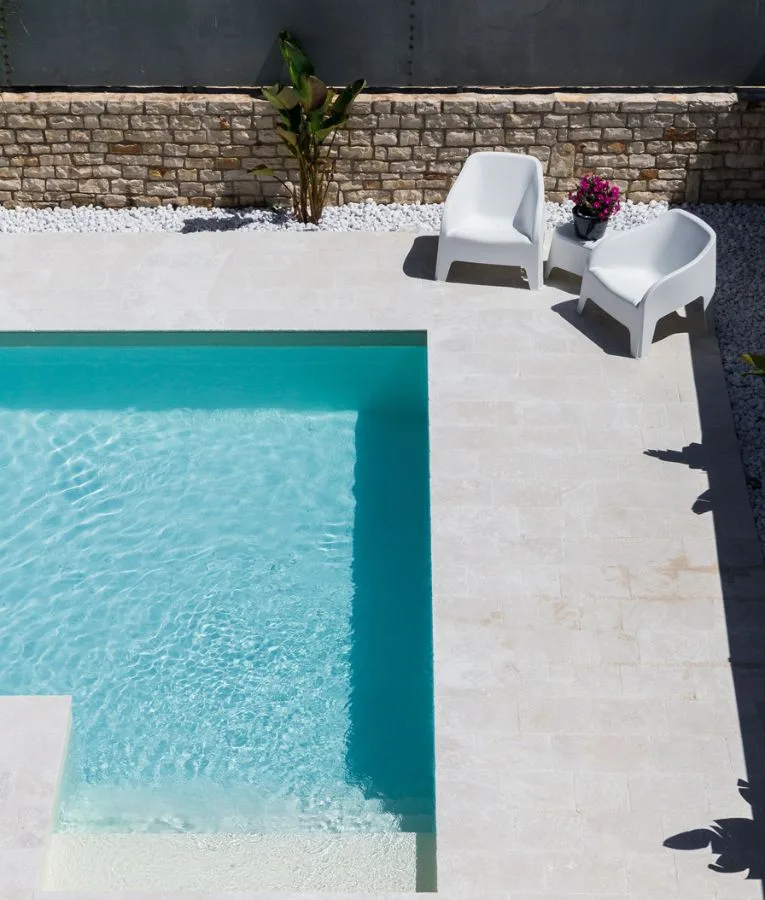 Pool of a private house in Trani seen from above, with edge and sun deck in pale stone slabs