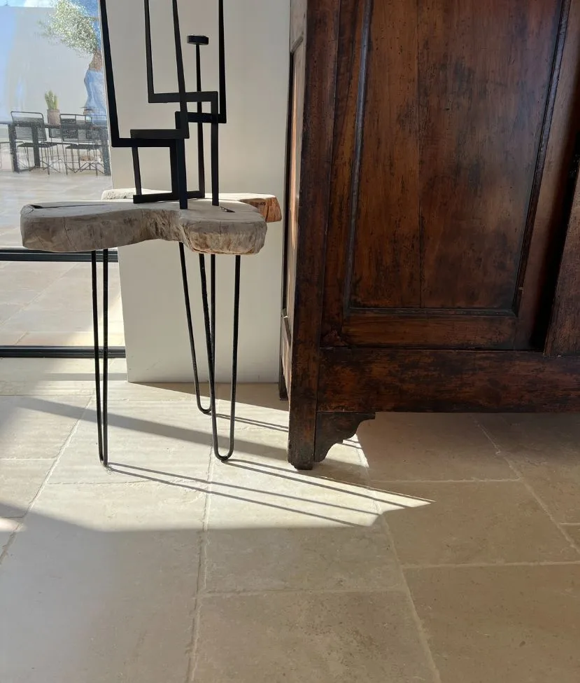 Détail du sol en dalles claires près d'une console et d'une armoire ancienne