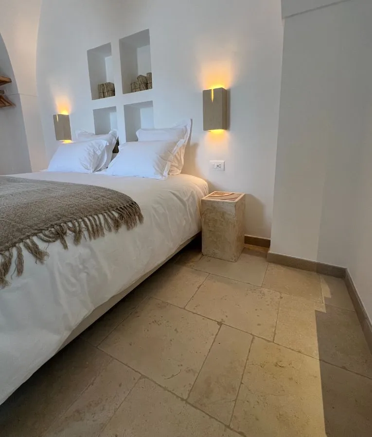Bedroom with wall niches and a floor in pale stone slabs