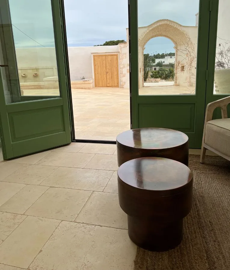 Green glazed doors at Masseria Valentina looking onto the courtyard, with a floor in pale stone slabs
