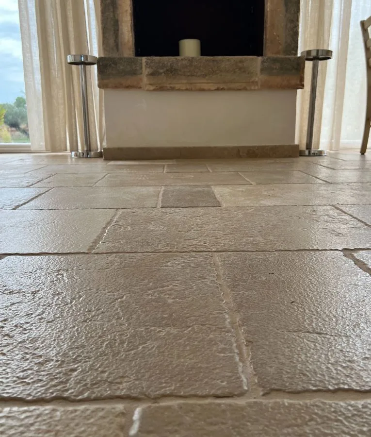 Detail of the floor in stone slabs in front of a stone fireplace